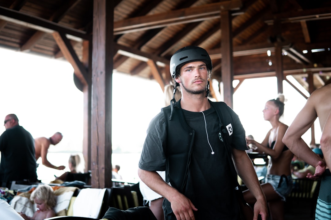 man in black polo shirt wearing black cap