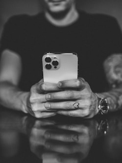grayscale photo of man holding iphone