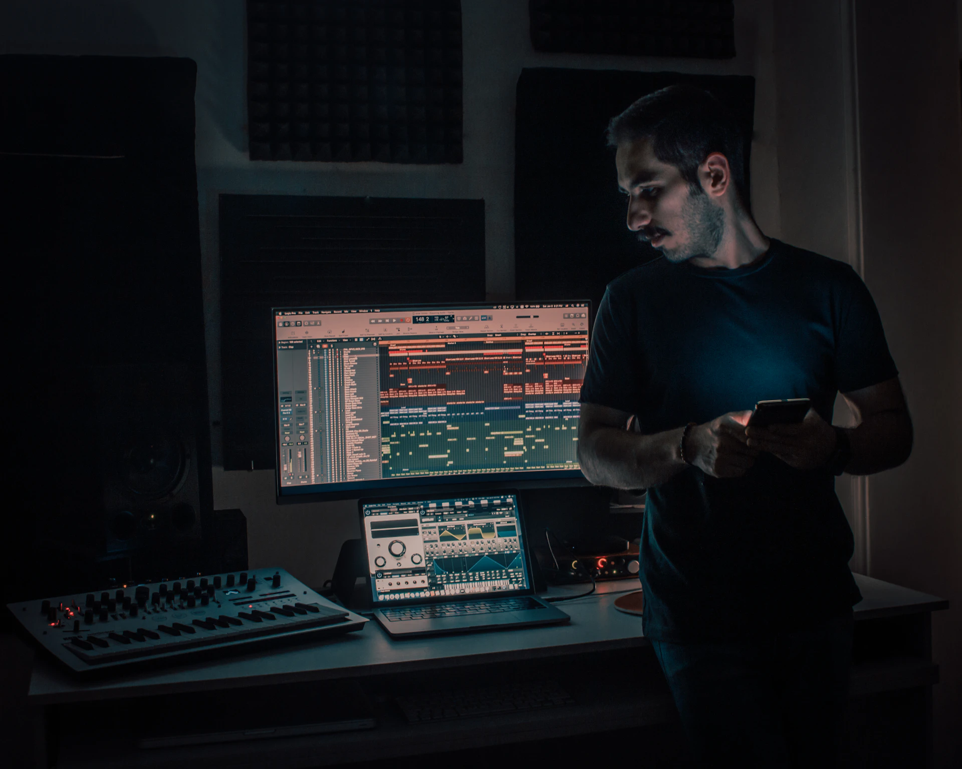 Designer at work on a studio monitor, moody lighting