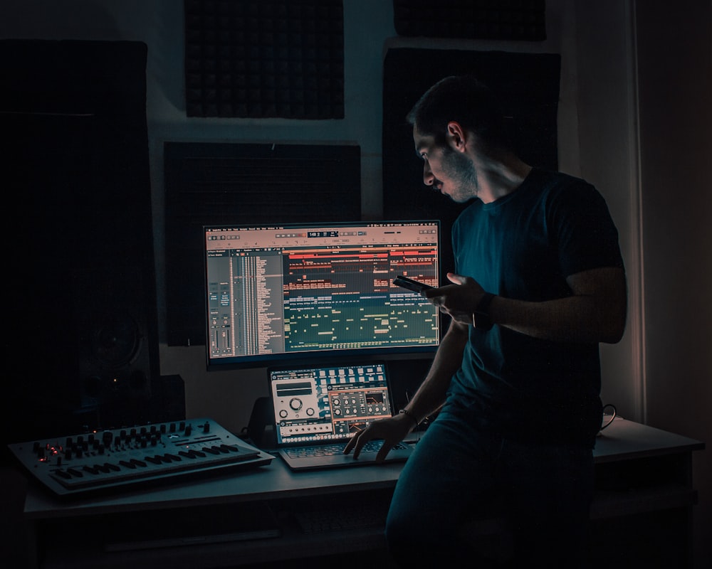 man in black crew neck t-shirt sitting on chair in front of computer