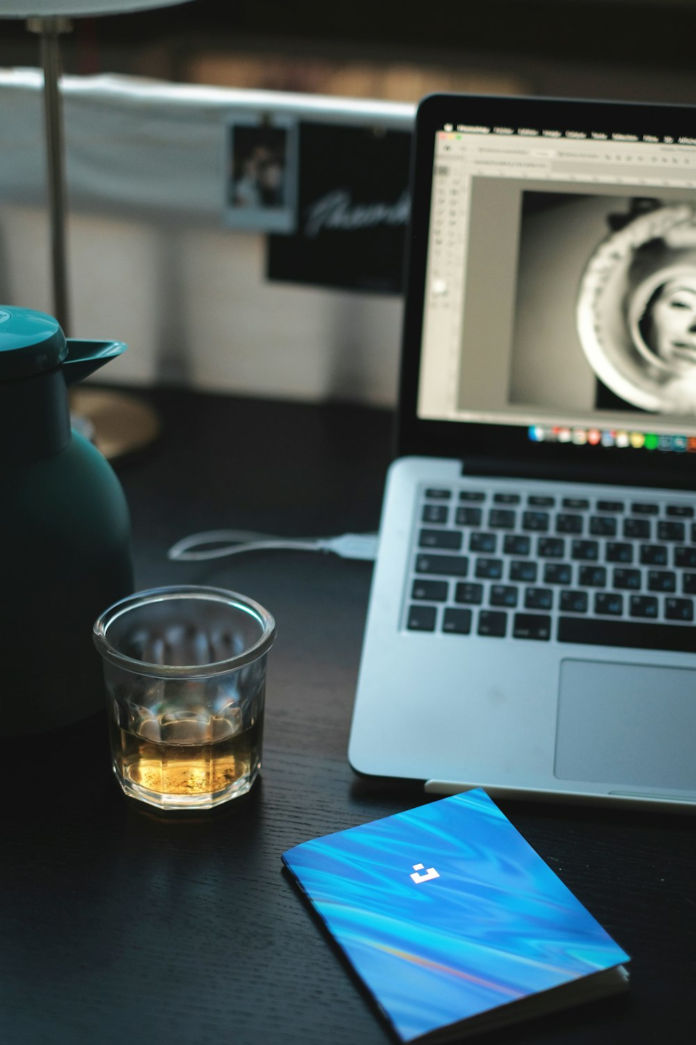 clear drinking glass beside macbook pro