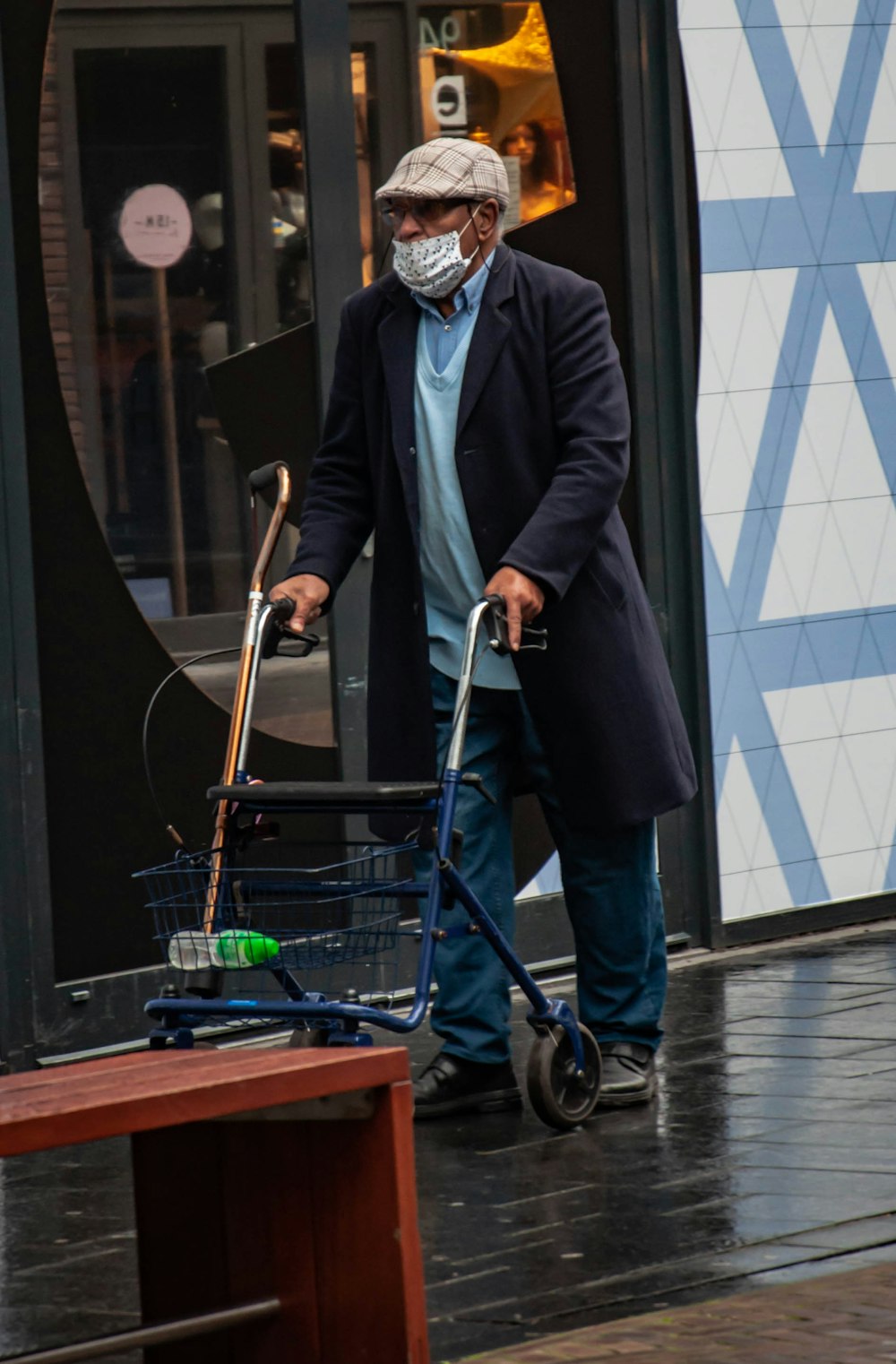 man in black suit jacket and white mask holding blue shopping cart