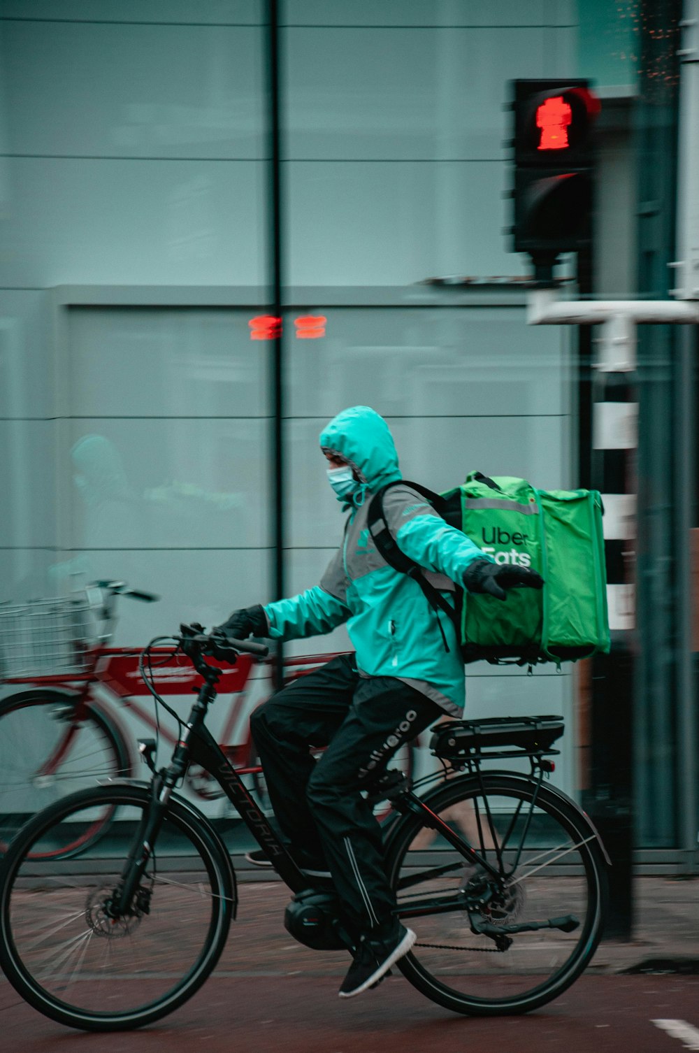 man in green jacket riding on black bicycle