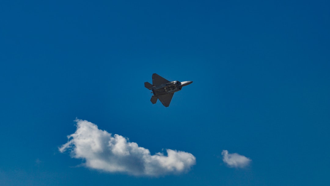 black jet plane in mid air under blue sky during daytime