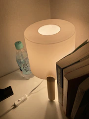 Close-up of a bedside table with a reading lamp and a book.