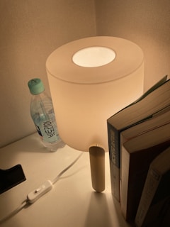 A cozy bedside table with a softly glowing lamp and a notebook for jotting down sleep thoughts.