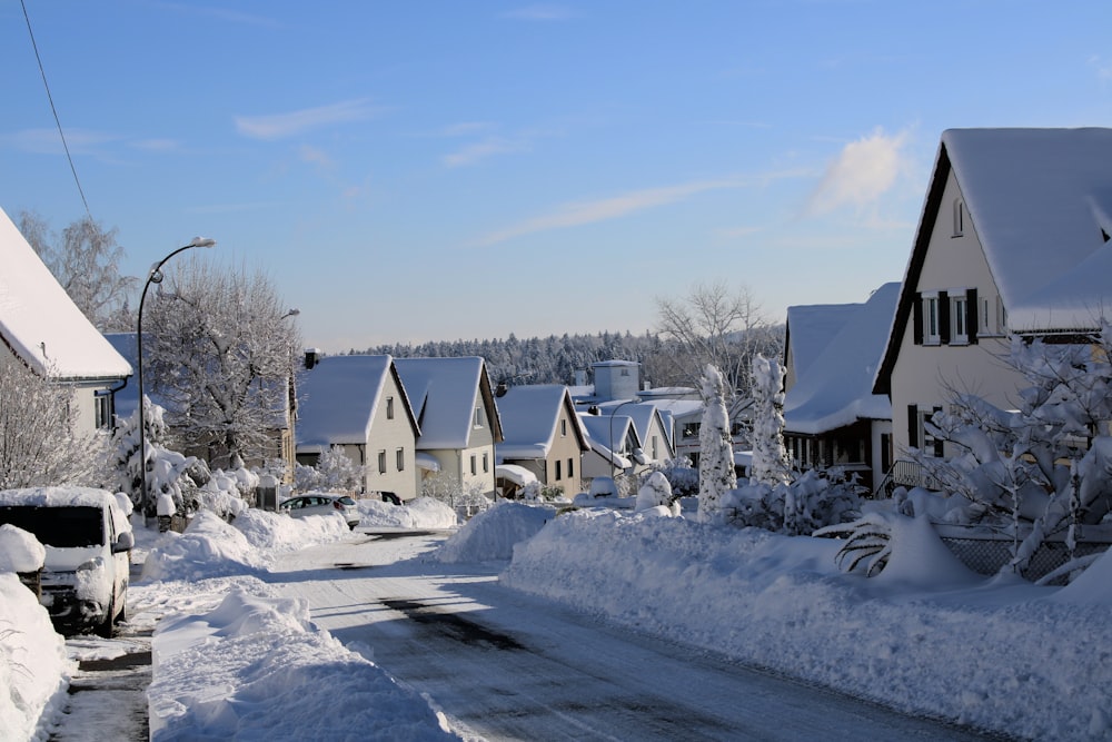snow covered houses and trees under blue sky during daytime