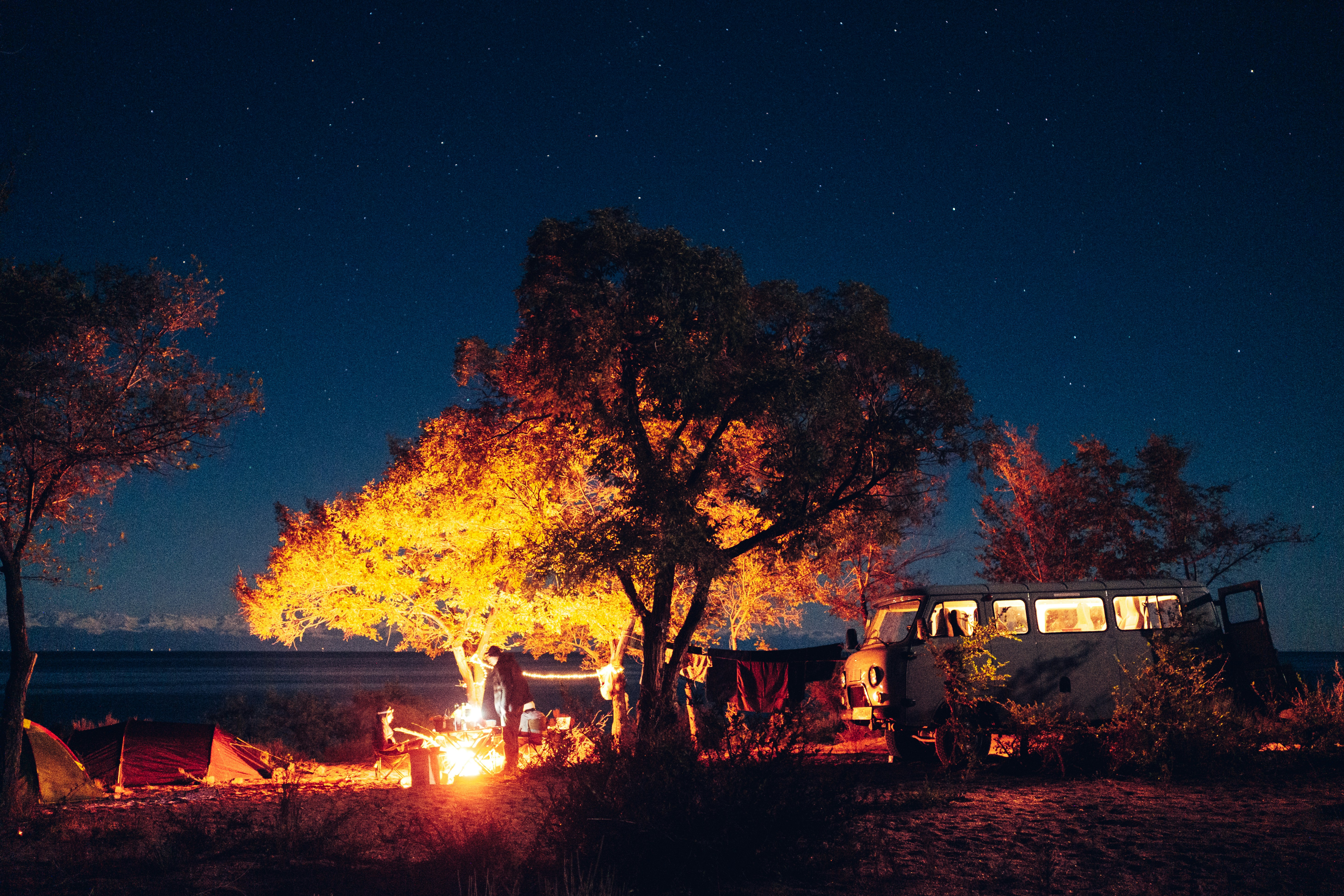 Happy international travelers relaxing at a glamping site in autumn