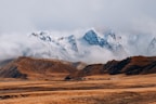 brown and white mountains under white clouds during daytime