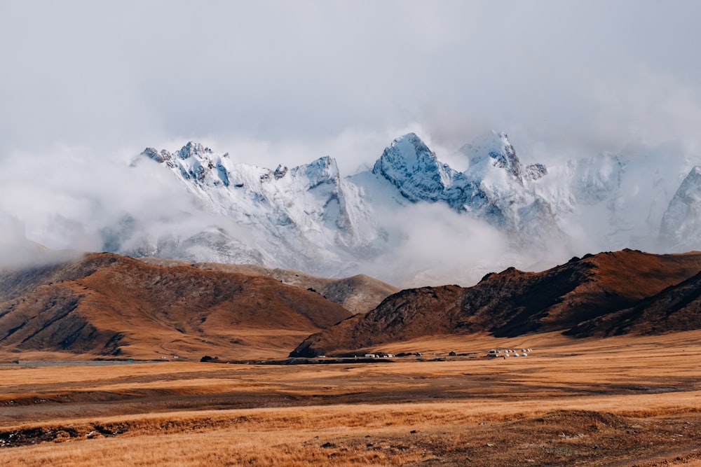 brown and white mountains under white clouds during daytime