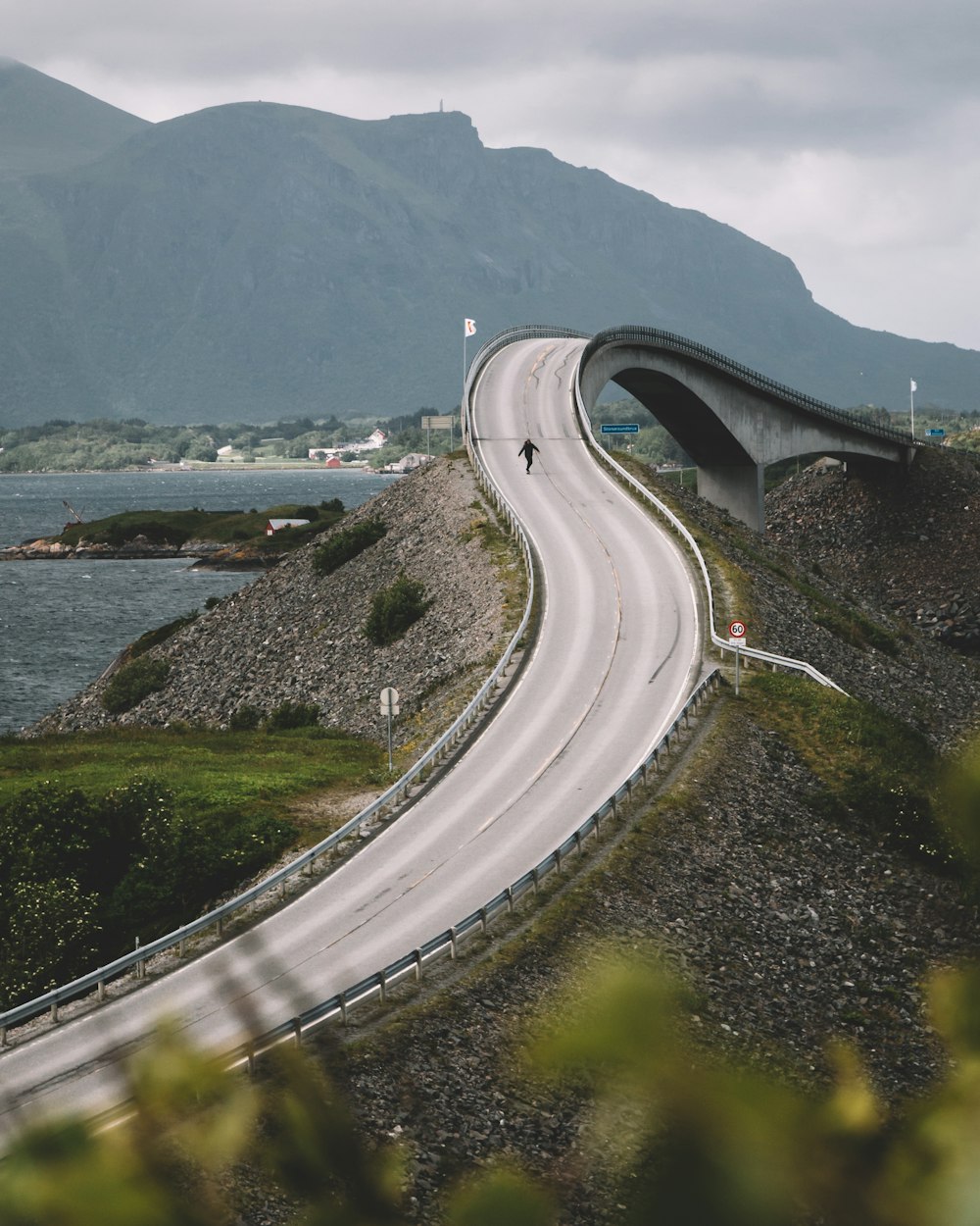 日中の水域近くの灰色のコンクリート道路