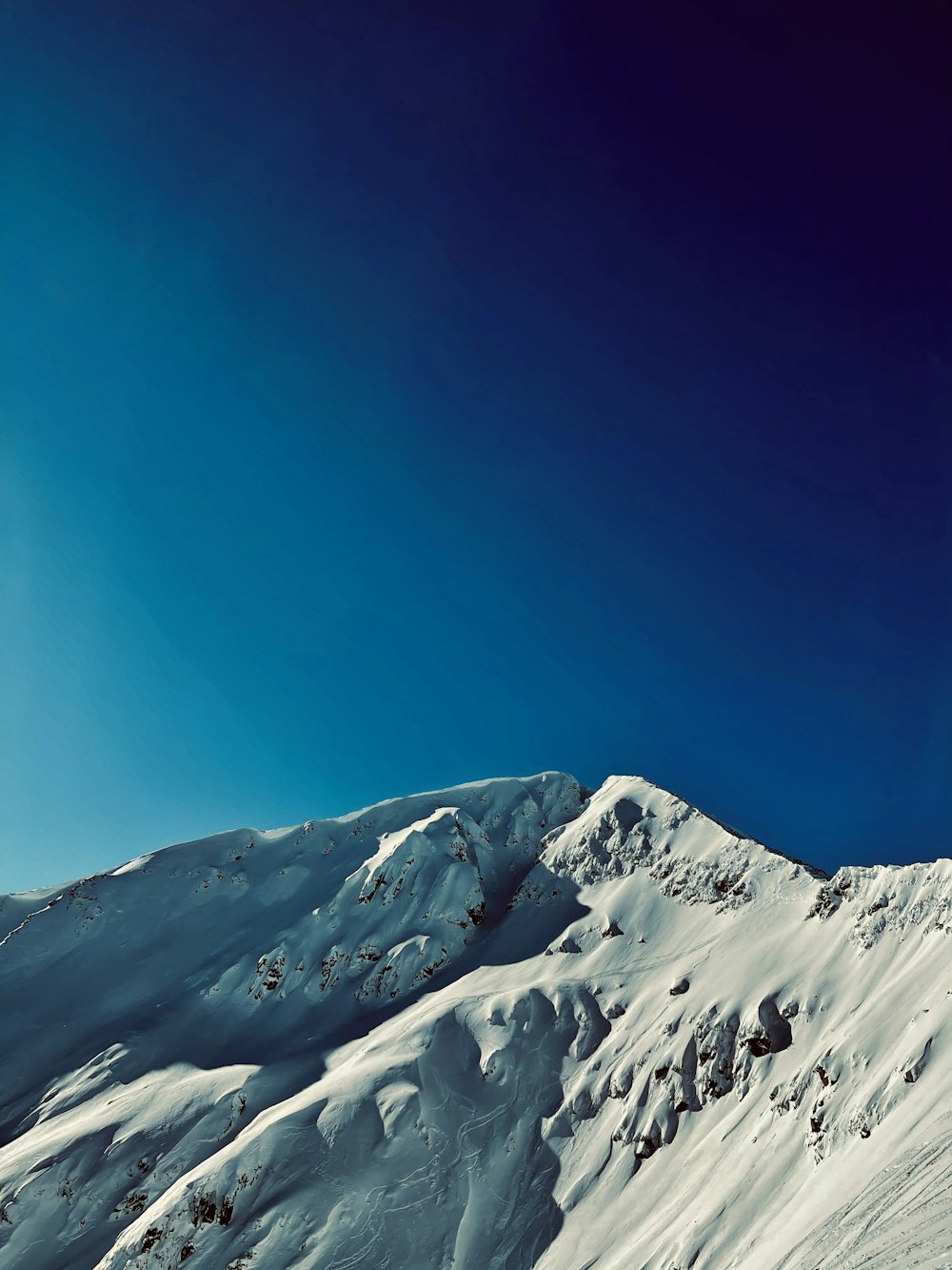 Montaña cubierta de nieve bajo el cielo azul durante el día