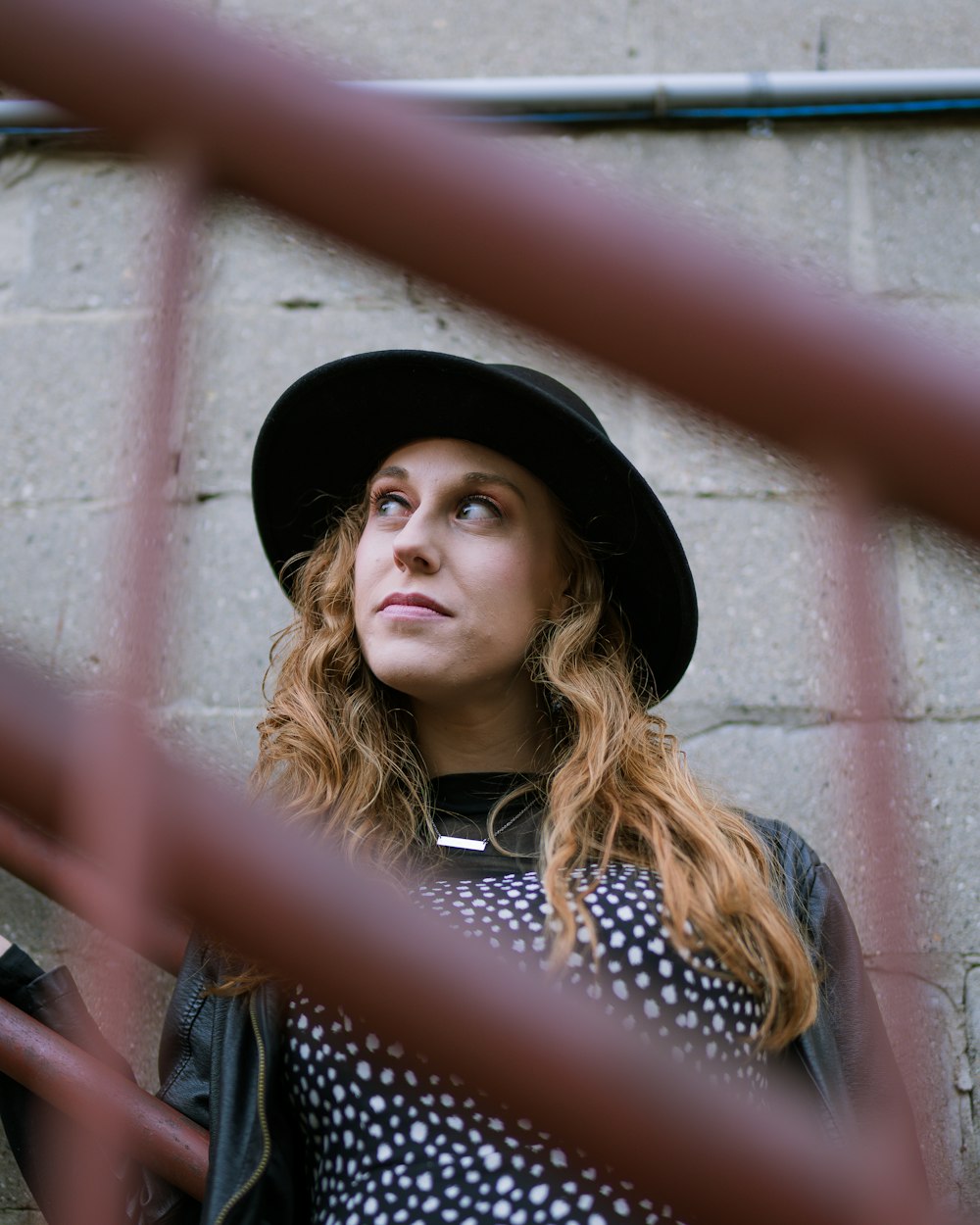 woman in black hat and white and black polka dot shirt