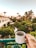 A smiling guest enjoying coffee on a balcony overlooking the garden.