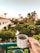 Smiling guest enjoying a sunny morning on the hotel balcony with a cup of coffee.