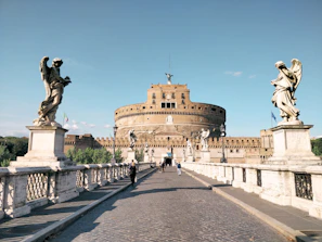 people walking on gray concrete pathway near brown concrete building during daytime