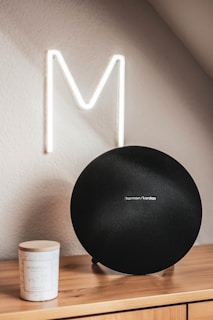 A sleek Bluetooth speaker placed on a modern wooden desk