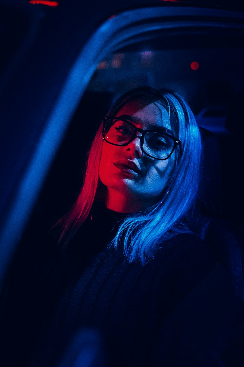 woman in black framed eyeglasses and black turtleneck sweater