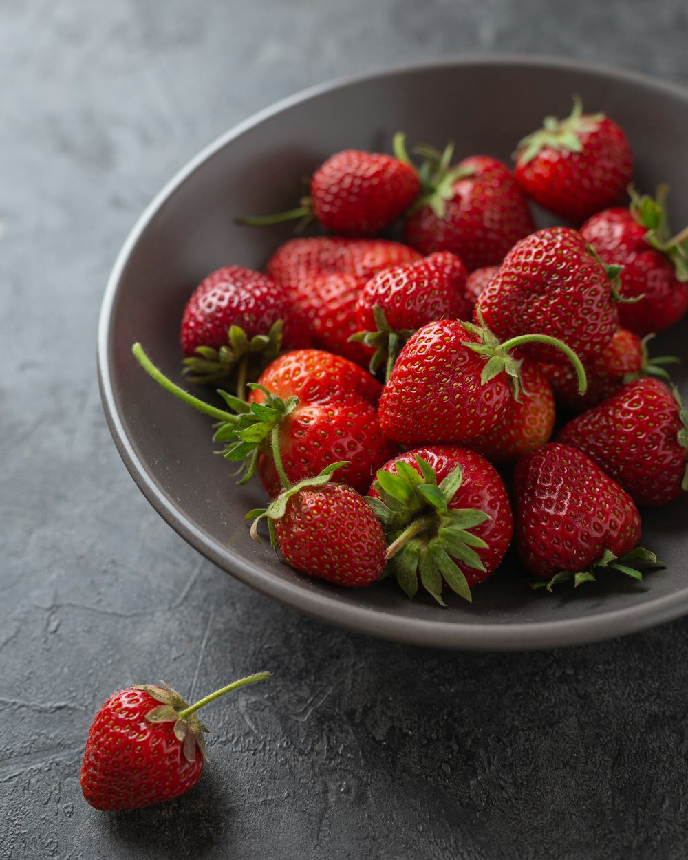 fresas en cuenco de cerámica blanca