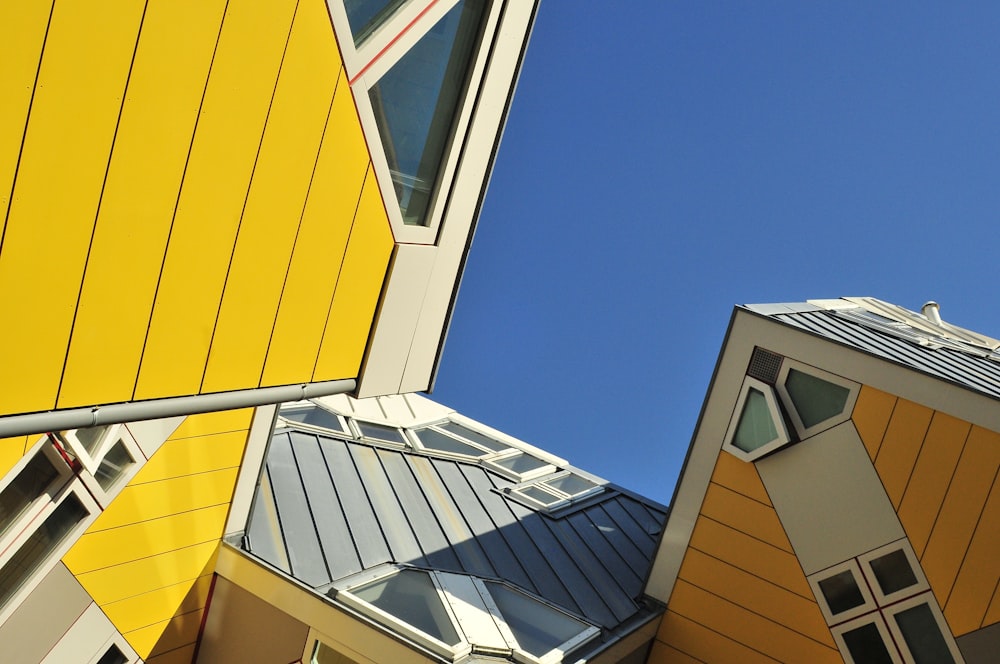 casa de madeira amarela e azul sob o céu azul durante o dia
