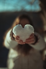 person holding white heart shaped ornament