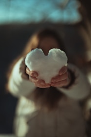 person holding white heart shaped ornament