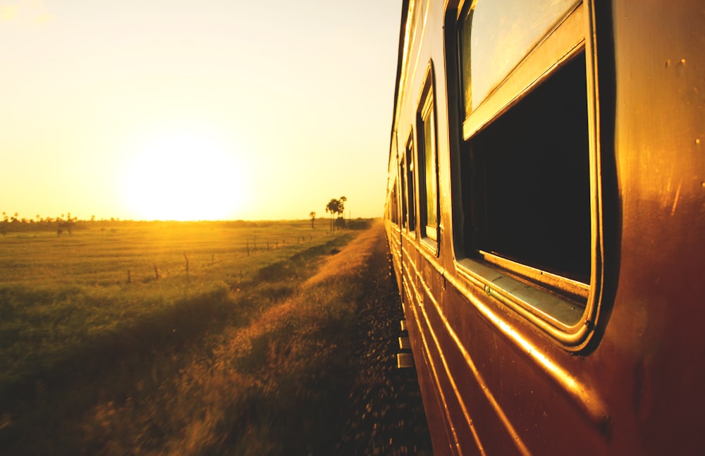 Tren blanco y negro sobre rieles durante la puesta del sol