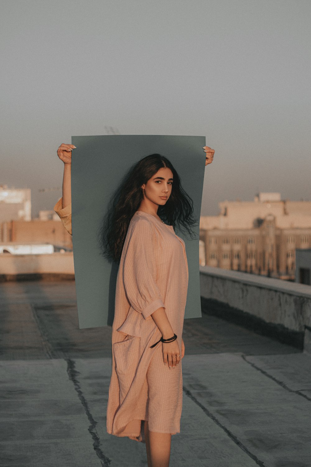 woman in white long sleeve dress standing on gray concrete floor during daytime