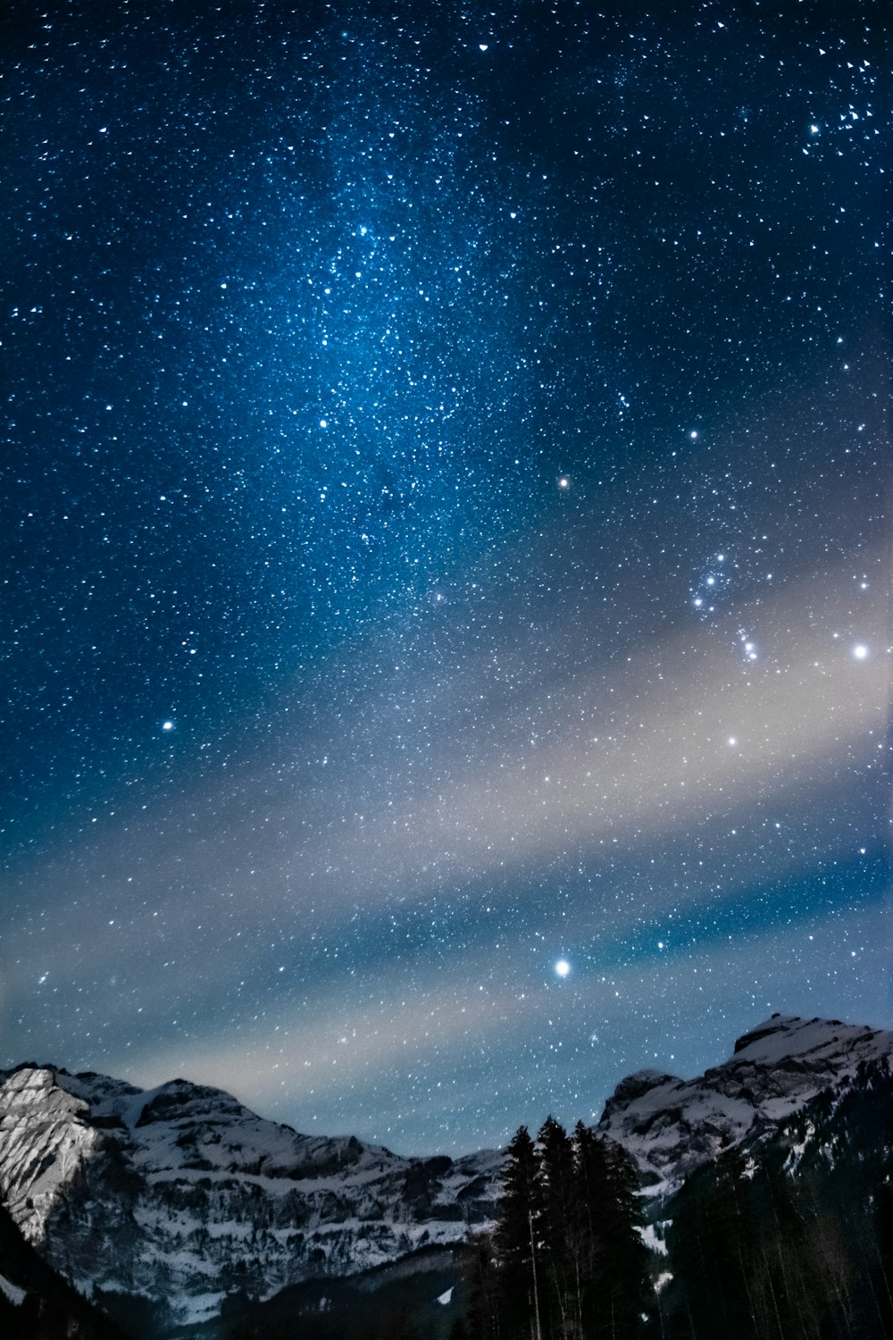 snow covered mountain under starry night