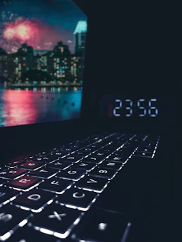 Hands typing on a sleek keyboard with a modern cityscape in soft focus behind, symbolizing forward movement.
