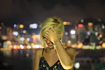 A young model wearing layered Lockend rings and bracelets against a city backdrop at dusk.
