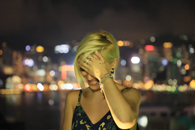 A young model wearing layered Lockend rings and bracelets against a city backdrop at dusk.