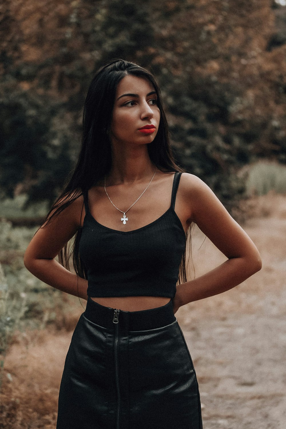 woman in black spaghetti strap top and black denim bottoms