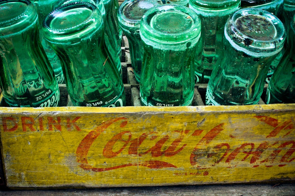 green glass bottles on brown wooden crate