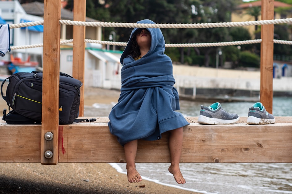 woman in blue hijab sitting on brown wooden bench