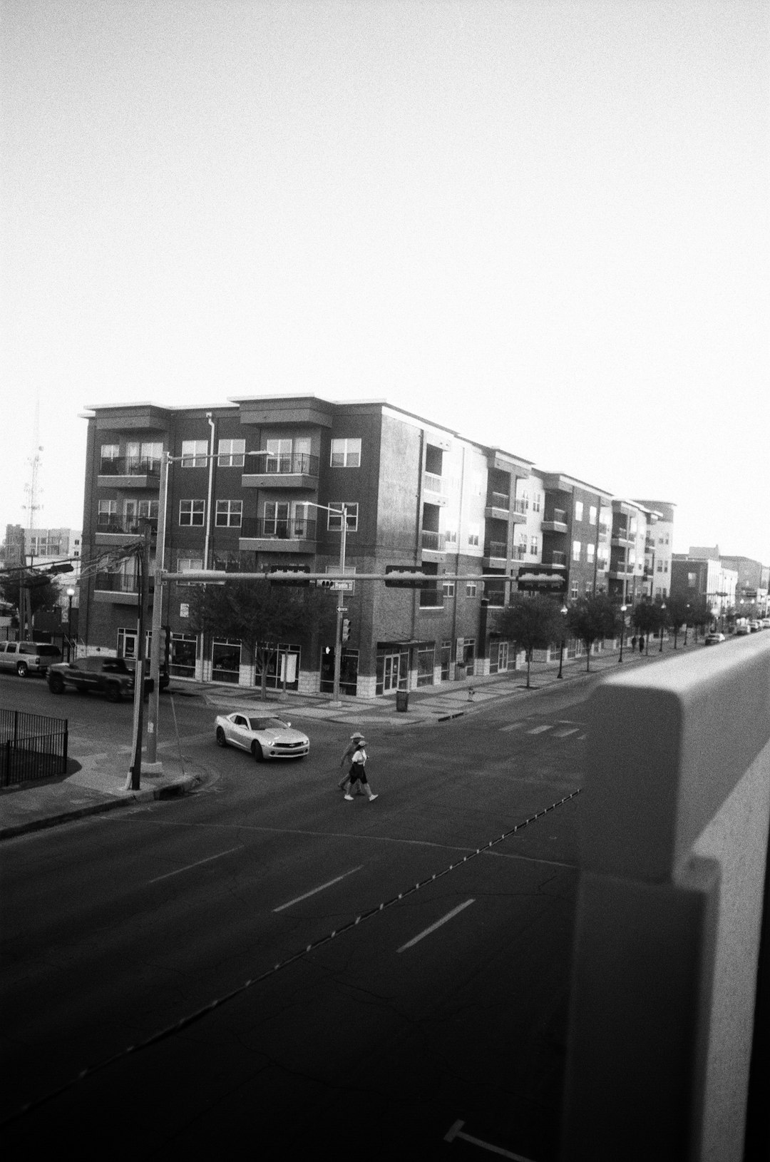 grayscale photo of cars on road near buildings