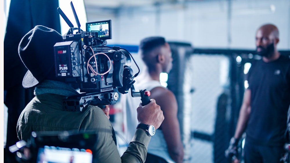 man in black jacket holding black video camera