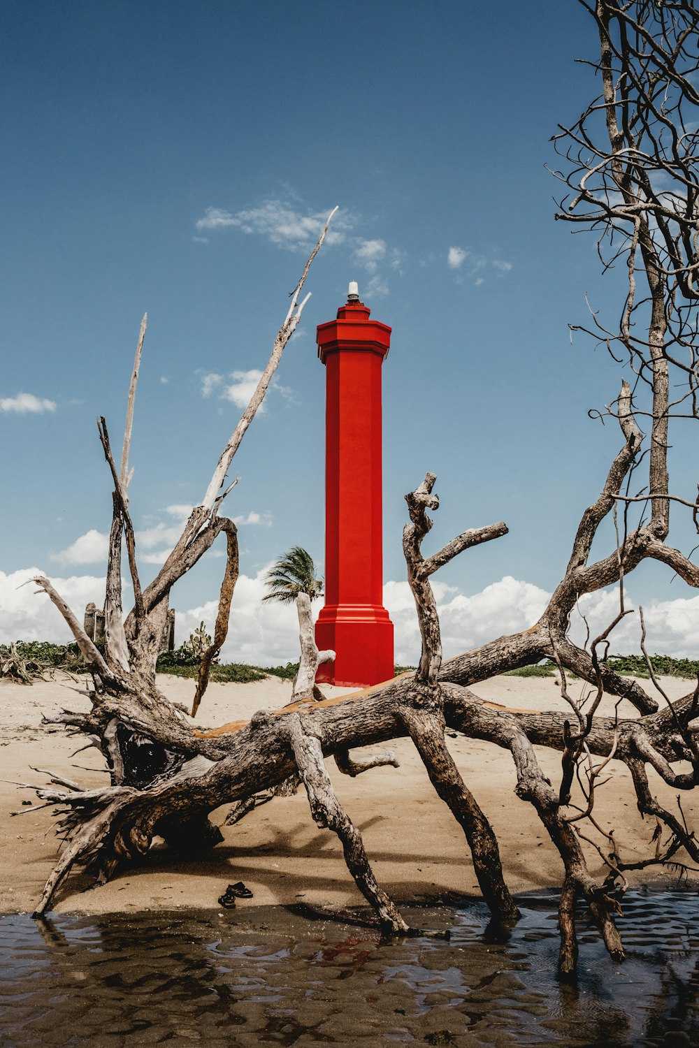 red and white concrete lighthouse under blue sky during daytime