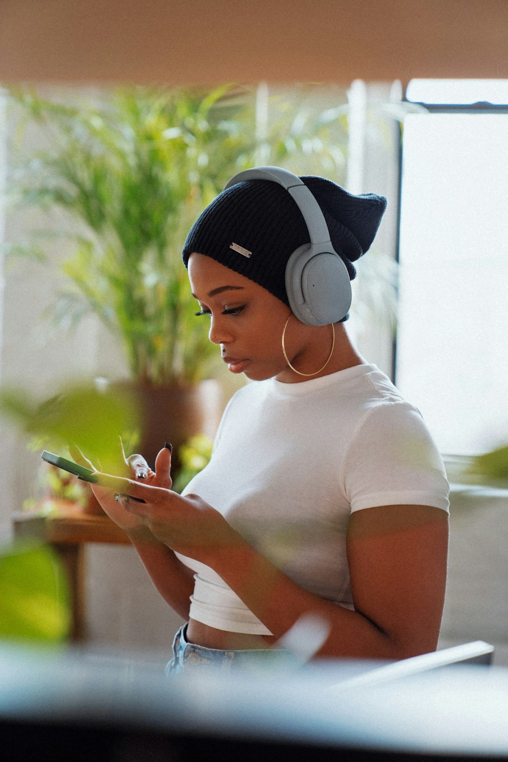 woman in white crew neck t-shirt holding smartphone