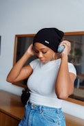 woman in white tank top and black knit cap