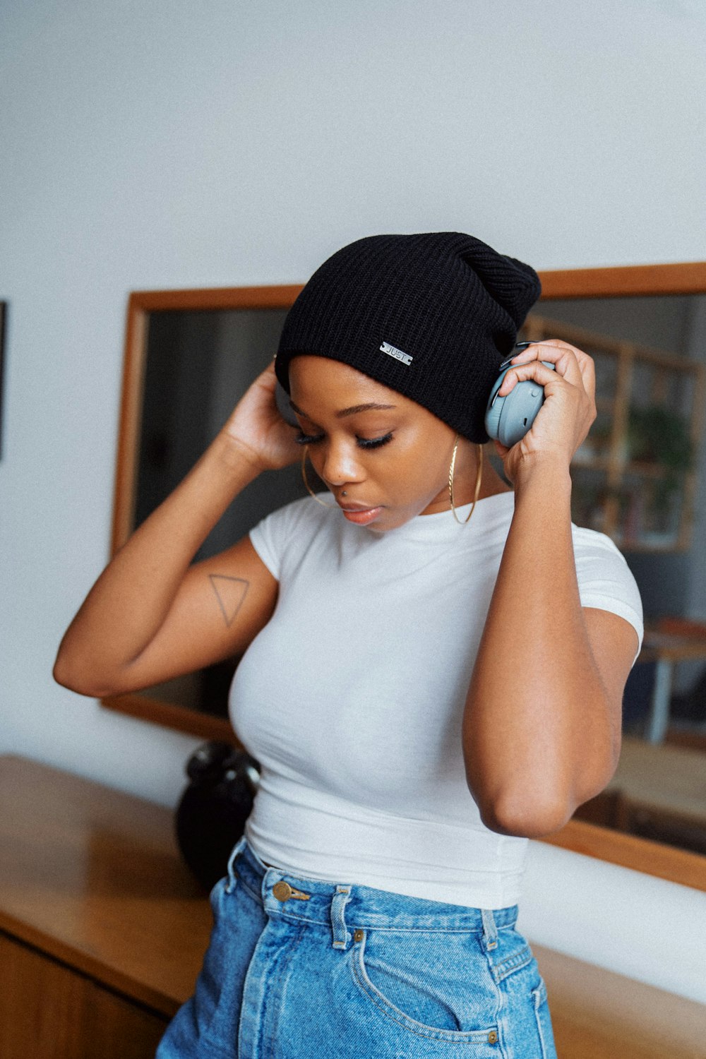 femme en débardeur blanc et bonnet en tricot noir