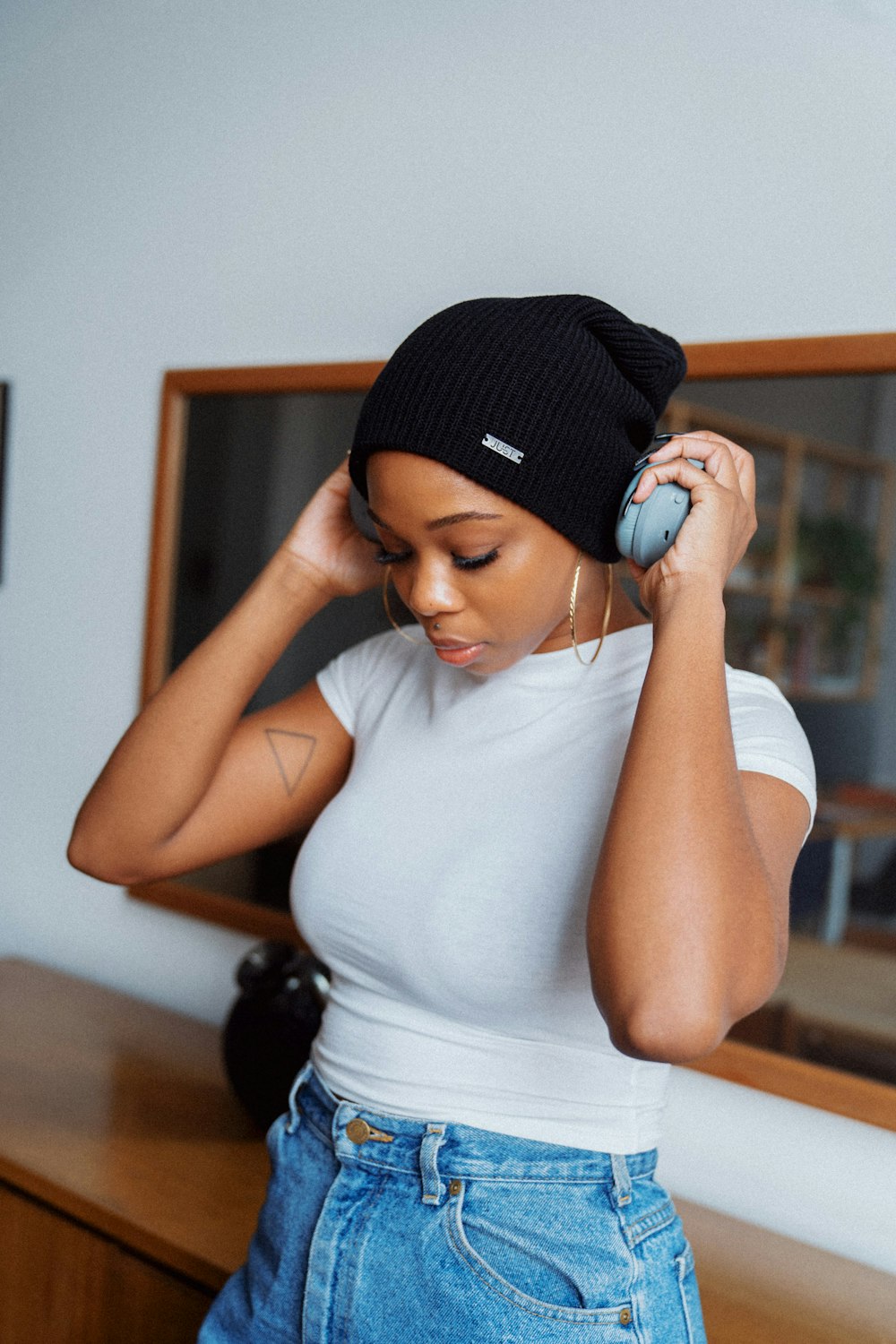 woman in white tank top and black knit cap
