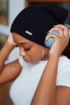 woman in white shirt wearing black knit cap