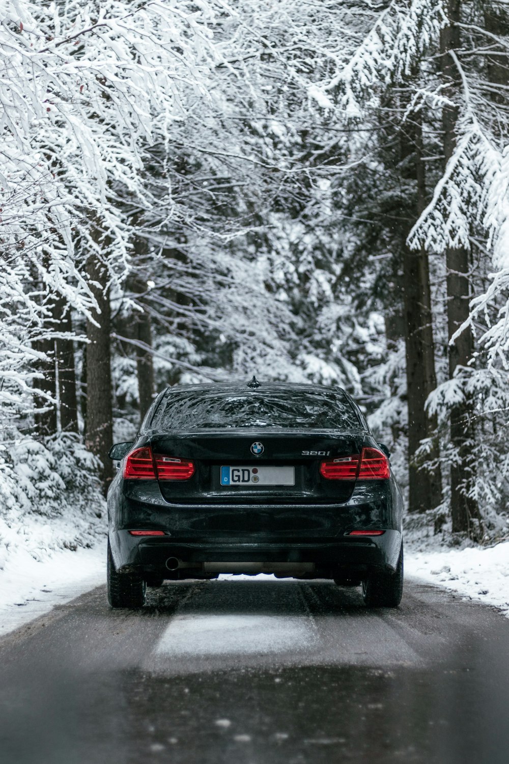 auto nera sulla strada coperta di neve