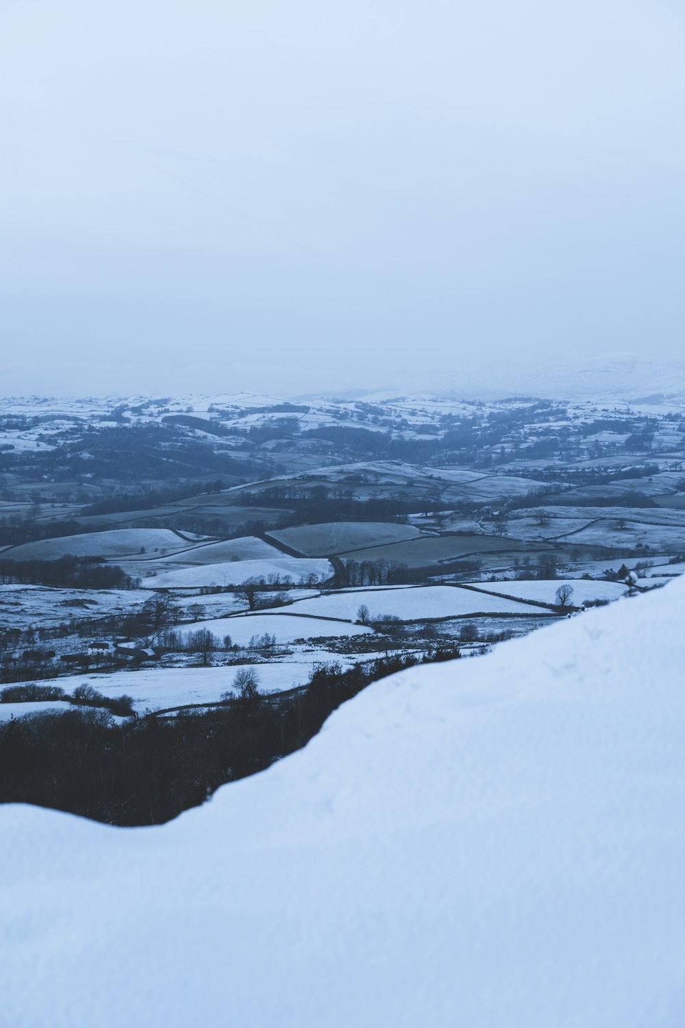 Schneebedecktes Feld unter weißem Himmel tagsüber