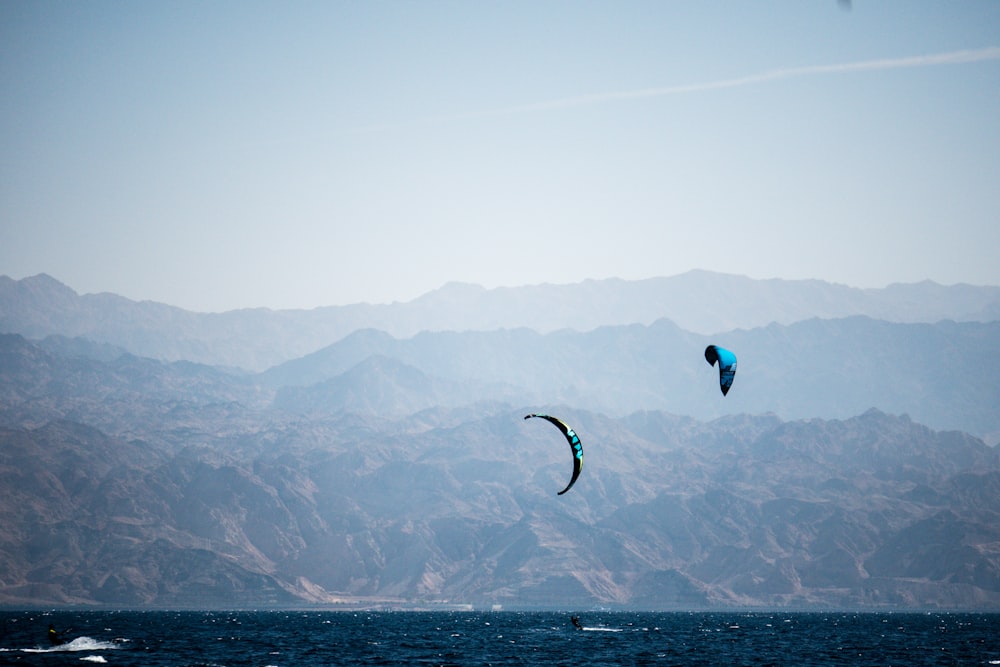 person in green and black parachute over the sea during daytime