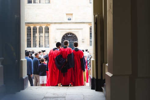 people in red robe walking on street during daytime