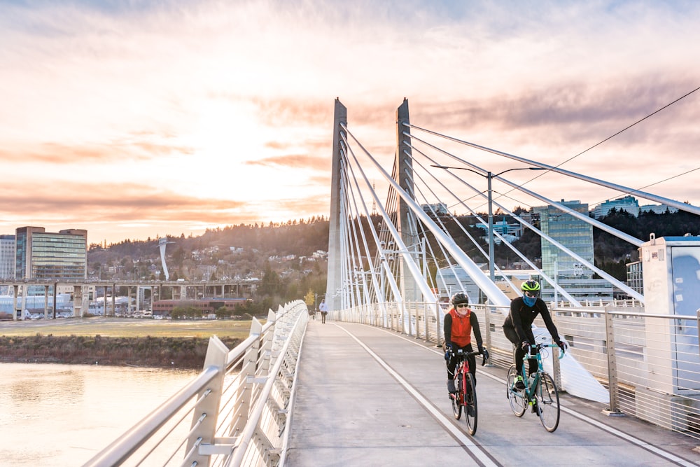 persone che vanno in bicicletta sul ponte durante il giorno