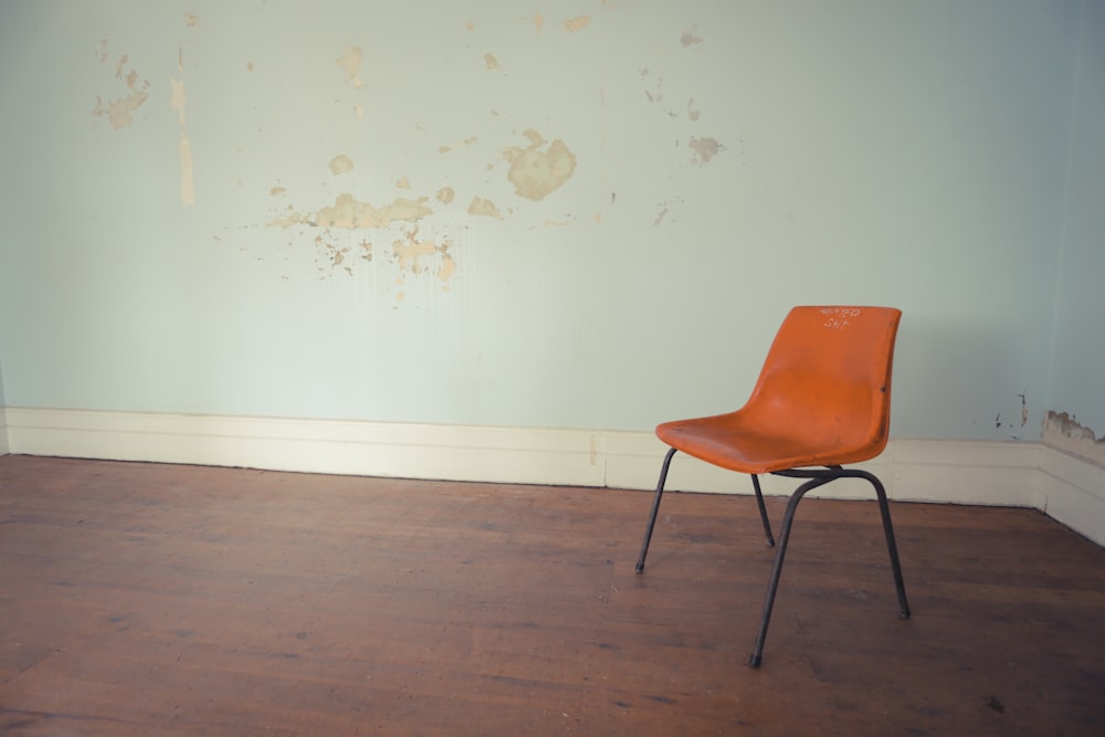 Chaise orange et noire près du mur