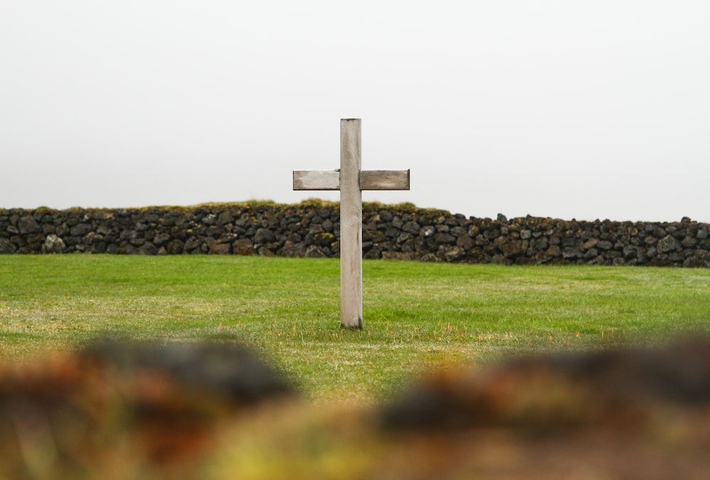 brown wooden cross on green grass field during daytime